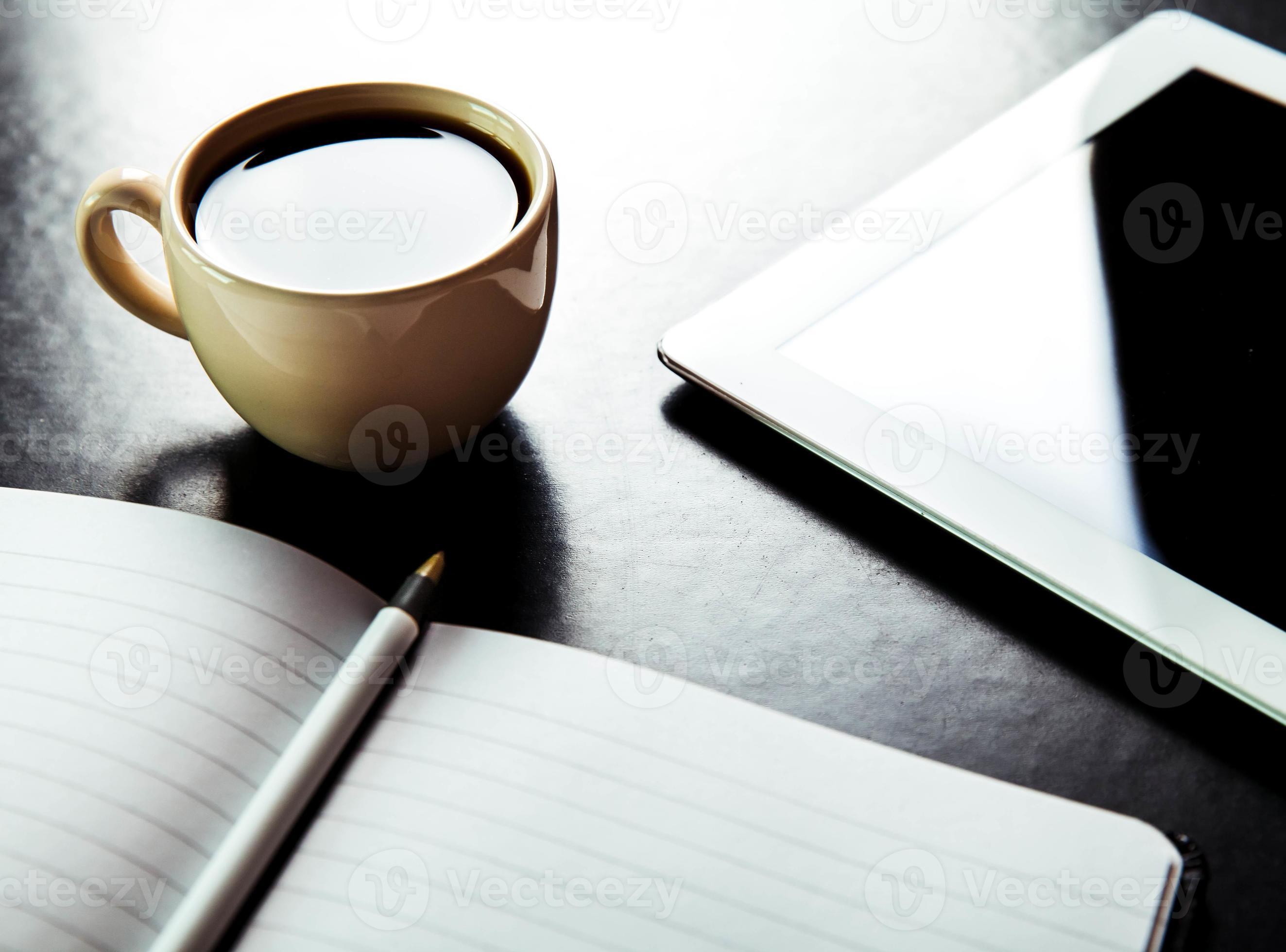 leerer Tablet-PC und Kaffee, Notizbuch mit Bleistift foto