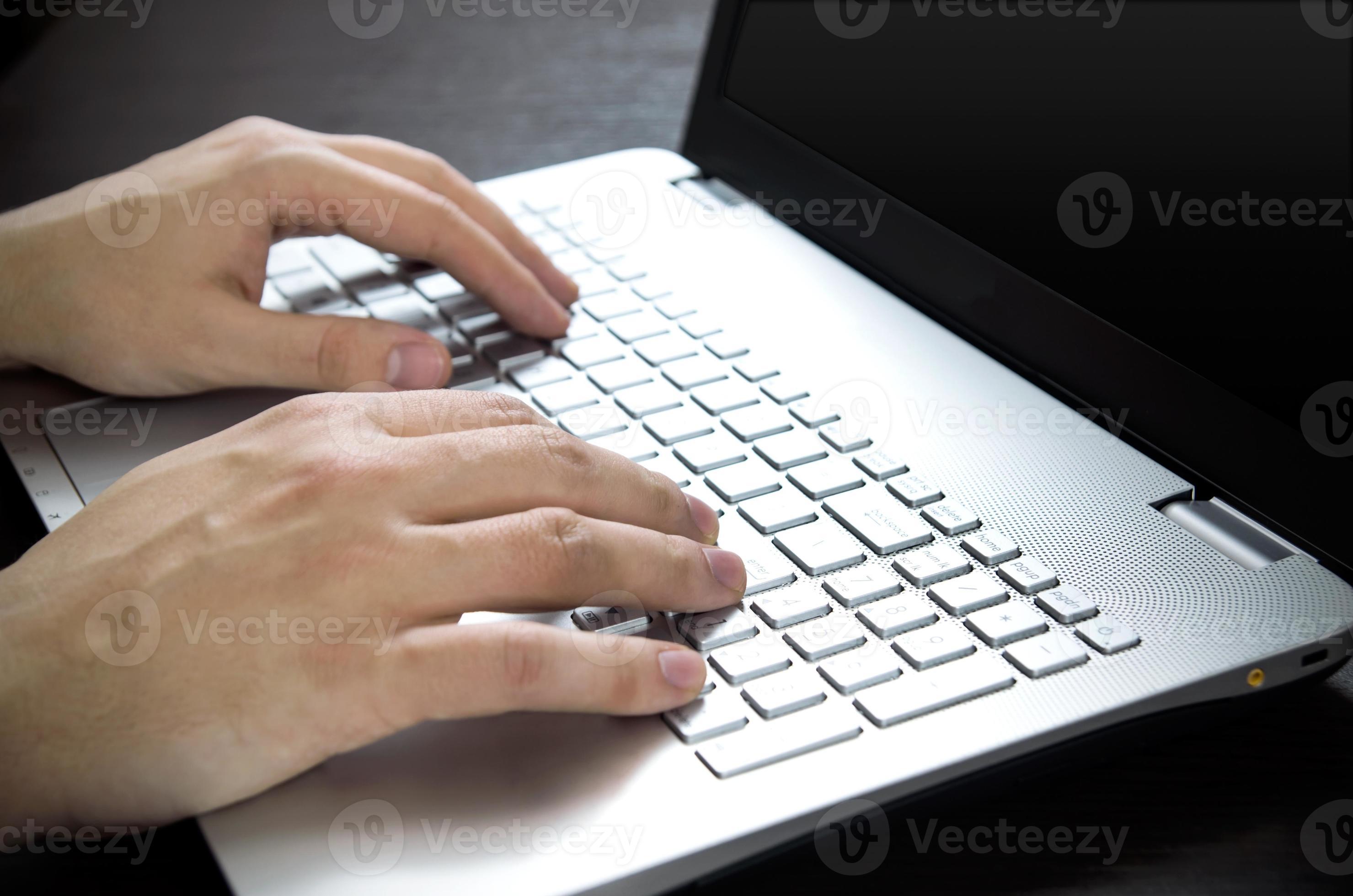 Mann mit Laptop mit weißer Tastatur. im Büro arbeiten foto