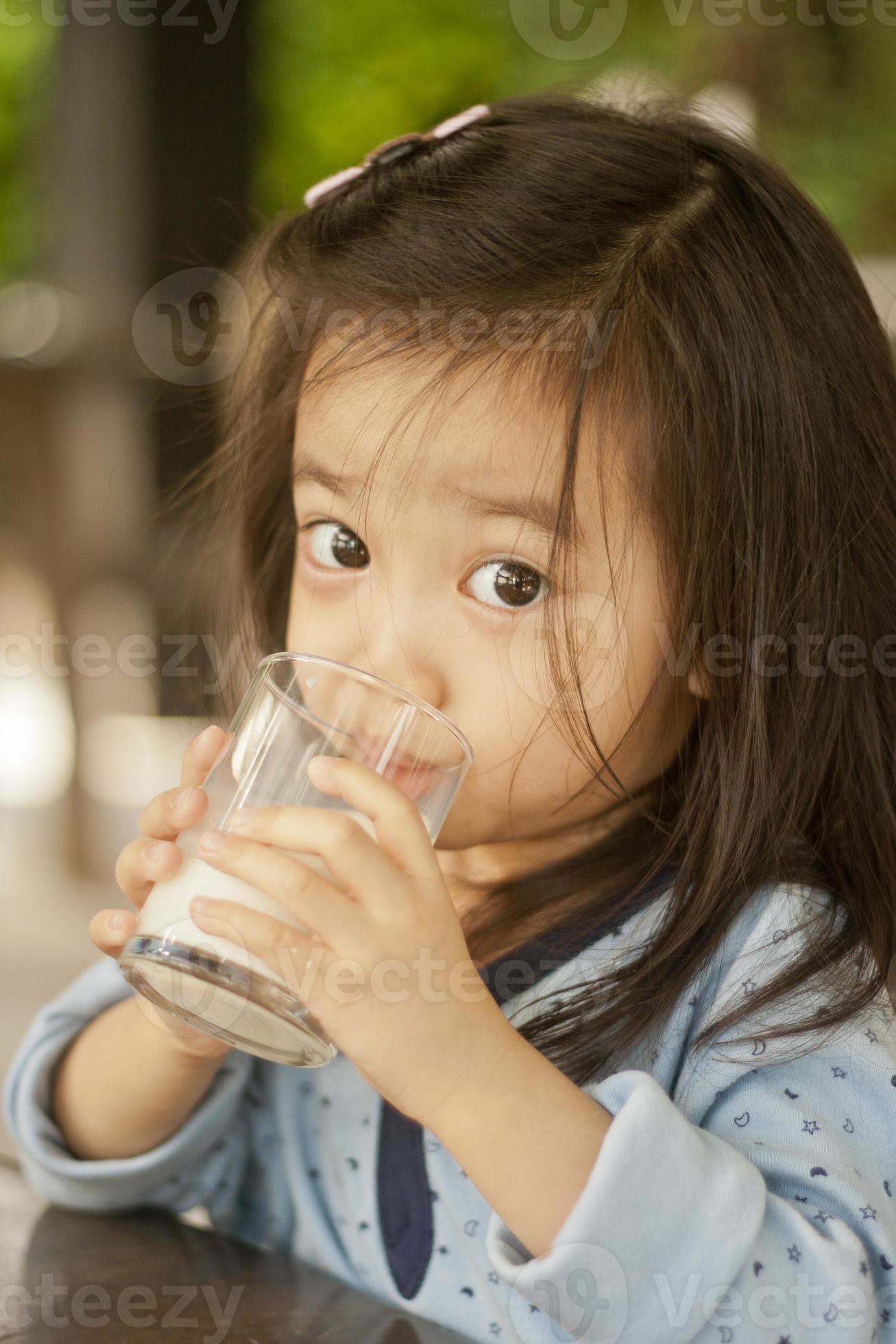 asiatisches süßes kleines Mädchen, das Milch trinkt foto