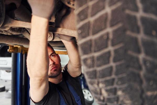 mit Spezialwerkzeug. Mann in Arbeitsuniform repariert weißes Auto drinnen.  Konzept des Autoservices 15293609 Stock-Photo bei Vecteezy