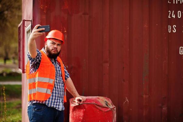 Bauarbeiter mit helm und weste macht ein selfie auf der baustelle