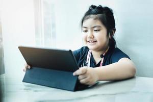 E-Learning, Online-Bildung und soziale Distanzierung im Internet schützen vor dem Konzept der Covid-19-Viren. asiatische kinder student videokonferenz e-learning mit lehrer auf tablet-computer zu hause.
