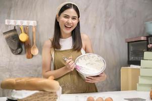 junge schöne frau backt in ihrem küchen-, bäckerei- und cafégeschäft foto