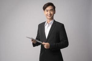 junger Geschäftsmann mit Anzug auf weißem Hintergrund Studio foto