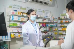 Porträt einer Apothekerin mit Gesichtsmaske in einer modernen Apotheke. foto