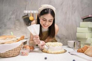 junge schöne frau backt in ihrem küchen-, bäckerei- und cafégeschäft foto