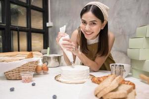 junge schöne frau backt in ihrem küchen-, bäckerei- und cafégeschäft foto