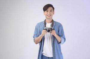 junger glücklicher asiatischer touristischer mann über weißem hintergrundstudio-, reise- und feiertagskonzept. foto