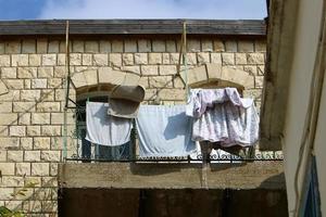 vor dem fenster wird wäsche an einem seil an der fassade des gebäudes getrocknet. foto