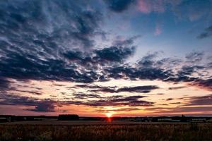 Hintergrund des blauen Himmels mit flauschigen, lockigen, rollenden Altocumulus-Altostratus-Wolken mit untergehender Sonne. gutes windiges Wetter foto