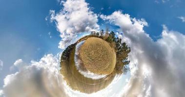 Transformation eines kleinen Planeten mit Raumkrümmung. sphärisches 360-Grad-Panorama am Ufer des Sees im sonnigen Sommer mit fantastischen Wolken. foto