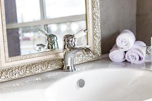 Wasserhahn Waschbecken mit Wasserhahn im teuren Loft-Badezimmer foto