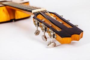 Stimmwirbel auf hölzernem Maschinenkopf einer Gitarre mit sechs Saiten auf weißem Hintergrund foto