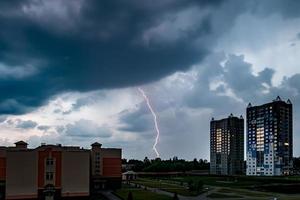 Gewitter mit Blitzschlag über Stadt. Moment Blitz foto