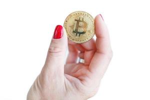 virtuelles geld goldene bitcoin frauen hand mit roten nägeln fingern isoliert auf weißem hintergrund foto