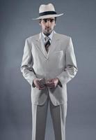 Mafia-Modemann, der weißen gestreiften Anzug und Hut trägt. foto