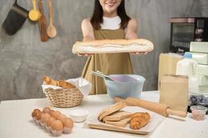 junge schöne frau backt in ihrem küchen-, bäckerei- und cafégeschäft foto