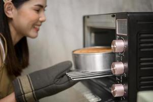 junge schöne frau backt in ihrem küchen-, bäckerei- und cafégeschäft foto