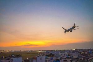 ho chi minh stadt, vietnam - 20. feb 2022 flugzeug fliegt über städtische gebiete und bereitet die landung auf dem internationalen flughafen tan son nhat vor und startet am flughafen tsn foto