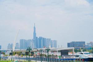 ho chi minh stadt, vietnam - 13. feb 2022 skyline mit wahrzeichen 81 wolkenkratzer, eine neue seilbrücke wird gebaut, die die halbinsel thu thiem und den bezirk 1 über den fluss saigon verbindet. foto