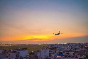 ho chi minh stadt, vietnam - 20. feb 2022 flugzeug fliegt über städtische gebiete und bereitet die landung auf dem internationalen flughafen tan son nhat vor und startet am flughafen tsn foto