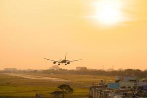 ho chi minh stadt, vietnam - 20. feb 2022 flugzeug fliegt über städtische gebiete und bereitet die landung auf dem internationalen flughafen tan son nhat vor und startet am flughafen tsn foto