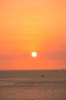 schöne sonnenuntergangstrandlandschaft, exotische tropische inselnatur, bunter rotgelber himmel, schattenbildschiff, goldene sonnenlichtreflexion, sommerferienferien. Himmel Wolke filmisch. foto