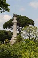 kleiner leuchtturm zwischen den bäumen in rom, italien foto