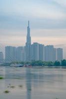 ho chi minh stadt, vietnam - 12. feb 2022 skyline mit wahrzeichen 81 wolkenkratzer, eine neue seilbrücke wird gebaut, die die halbinsel thu thiem und den bezirk 1 über den fluss saigon verbindet. foto