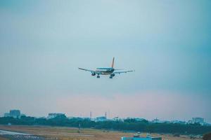 ho chi minh stadt, vietnam - 12. feb 2022 flugzeug fliegt über städtische gebiete und bereitet die landung auf dem internationalen flughafen tan son nhat vor und startet am flughafen tsn foto