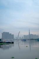 ho chi minh stadt, vietnam - 12. feb 2022 skyline mit wahrzeichen 81 wolkenkratzer, eine neue seilbrücke wird gebaut, die die halbinsel thu thiem und den bezirk 1 über den fluss saigon verbindet. foto