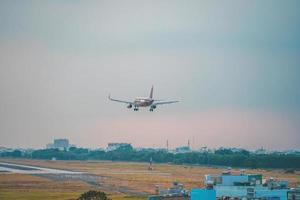 ho chi minh stadt, vietnam - 12. feb 2022 flugzeug fliegt über städtische gebiete und bereitet die landung auf dem internationalen flughafen tan son nhat vor und startet am flughafen tsn foto