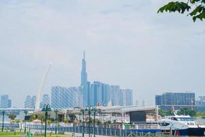 ho chi minh stadt, vietnam - 13. feb 2022 skyline mit wahrzeichen 81 wolkenkratzer, eine neue seilbrücke wird gebaut, die die halbinsel thu thiem und den bezirk 1 über den fluss saigon verbindet. foto