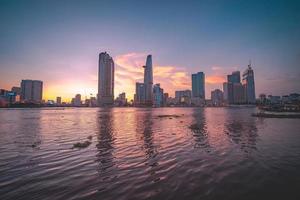 ho chi minh, vietnam - 13. feb 2022 blick auf bitexco financial tower building, gebäude, straßen, thu thiem bridge und saigon river in ho chi minh city bei sonnenuntergang. hochwertiges Panoramabild. foto