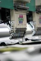 Moderne und automatische High-Tech-Nähmaschine für die Herstellung von Textil- oder Bekleidungsbekleidung in der Industrie. digitale Textilindustrie. computergestützte Stickerei. foto