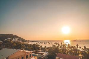 Luftaufnahme der Stadt Vung Tau mit wunderschönem Sonnenuntergang und so vielen Booten. Panoramablick auf die Küste von Vung Tau von oben, mit Wellen, Küste, Straßen, Kokospalmen und dem Berg Tao Phung in Vietnam. foto