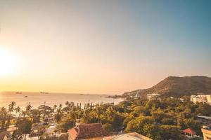 Luftaufnahme der Stadt Vung Tau mit wunderschönem Sonnenuntergang und so vielen Booten. Panoramablick auf die Küste von Vung Tau von oben, mit Wellen, Küste, Straßen, Kokospalmen und dem Berg Tao Phung in Vietnam. foto