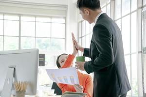 glückliches asiatisches geschäftsteam, das im büro zusammenarbeitet foto