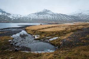 die schöne landschaftsansicht der berge in stodvarfjordur von ostisland am bewölkten tag. foto
