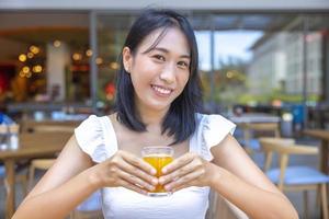 Frau beim Frühstück. Früchte wie Wassermelone, Papaya, Melone, Maracuja, Orangensaft und Kaffee. platziert auf einem grauen Tischset foto