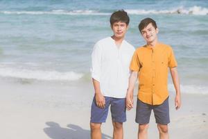 homosexuelles porträt junges asiatisches paar, das im sommer zusammen am strand steht, asien homosexuelle halten sich an den händen, gehen zur freizeit aufs meer und entspannen sich mit romantischen und glücklichen ferien auf meer, lgbt mit rechtlichem konzept. foto