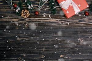 weihnachtsfeiertagskomposition mit roter geschenkboxdekoration auf holzhintergrund, neujahr und weihnachten oder jahrestag mit geschenken auf holztisch in der saison, draufsicht oder flachlage. foto