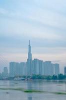 ho chi minh stadt, vietnam - 12. feb 2022 skyline mit wahrzeichen 81 wolkenkratzer, eine neue seilbrücke wird gebaut, die die halbinsel thu thiem und den bezirk 1 über den fluss saigon verbindet. foto