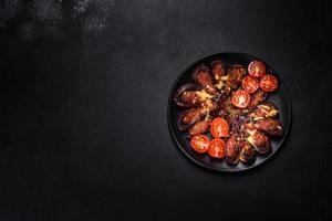 frische Auberginen gebacken mit Hackfleisch, Gewürzen und Kräutern auf einem schwarzen Teller