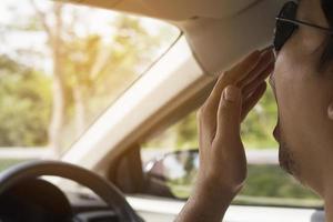 schläfriger gähnender mann, der ein auto fährt foto