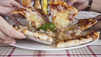 Familienmittagessen, das Pizza-Schinken-Käse-Rezept isst - Menschen mit italienischem Gerichtkonzept foto