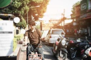 asiatischer touristenmann in einer stadt mit fahrrad - städtisches straßenreisekonzept foto