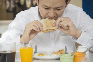 Geschäftsmann isst das amerikanische Frühstück in einem Hotel - die Leute frühstücken im Hotelkonzept foto
