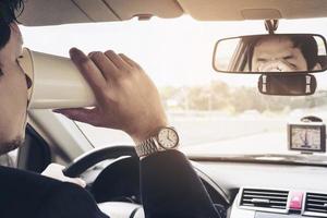 Mann, der Auto mit Navigator fährt und Kaffeetasse hält foto