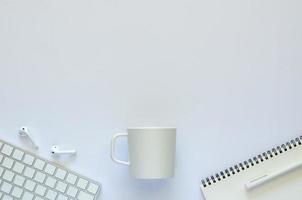 Hintergrund des Arbeitsraumkonzepts mit Kaffeetasse und Büromaterial auf weißem Hintergrund. foto